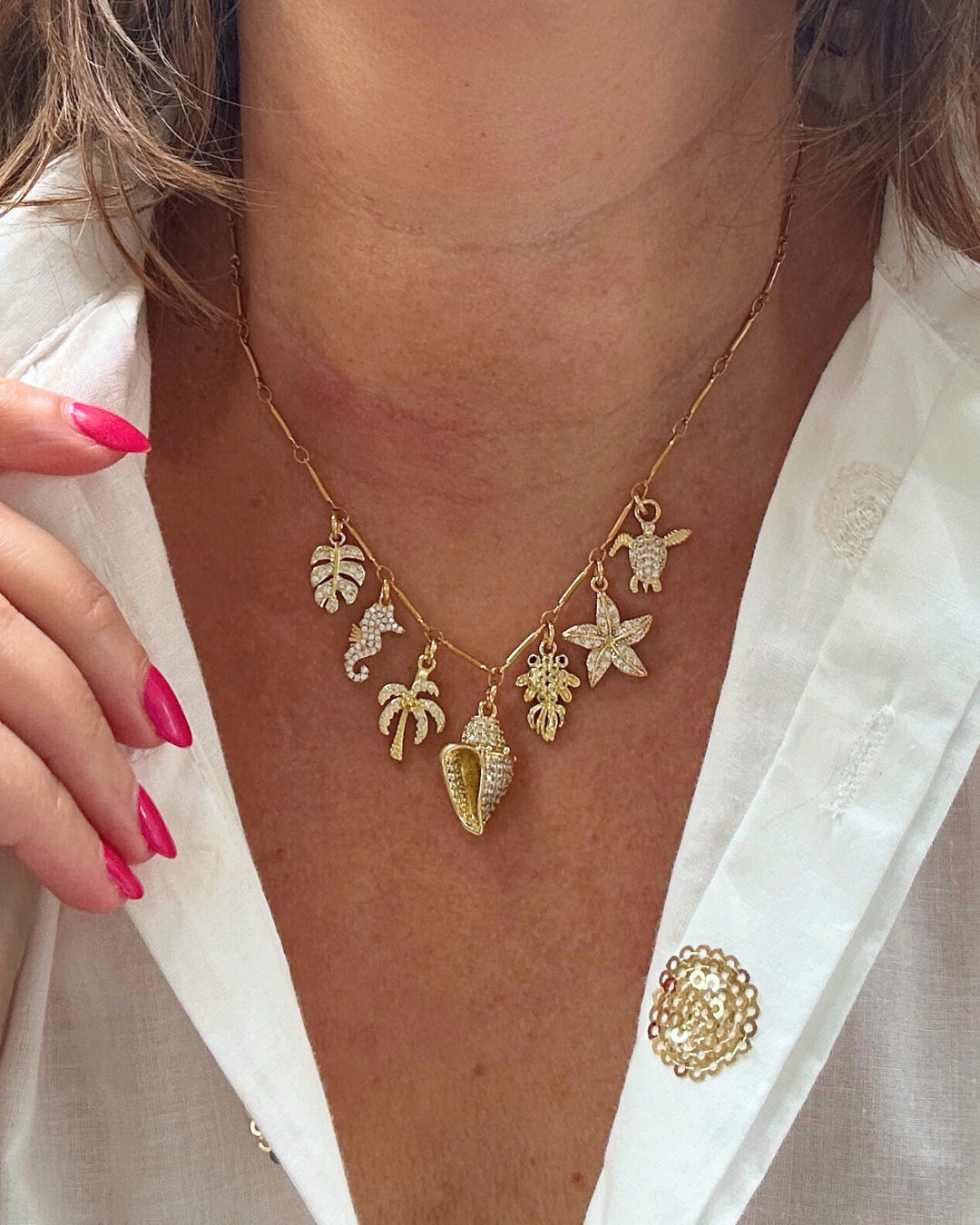 Laat je verleiden door de fonkeling van de zee.
Deze elegante gouden bedelketting is een ode aan zon, zee en zomerse charme. Met schitterende zirkonia bedels in de vorm van schelpjes, visjes, zeesterren, en alles wat er in de zee te vinden is, vangt deze ketting de magie van de oceaan in elke beweging.
Een stijlvolle eyecatcher die moeiteloos aansluit bij de trends van nu, en jouw look direct een sprankelende, zomerse upgrade geeft.