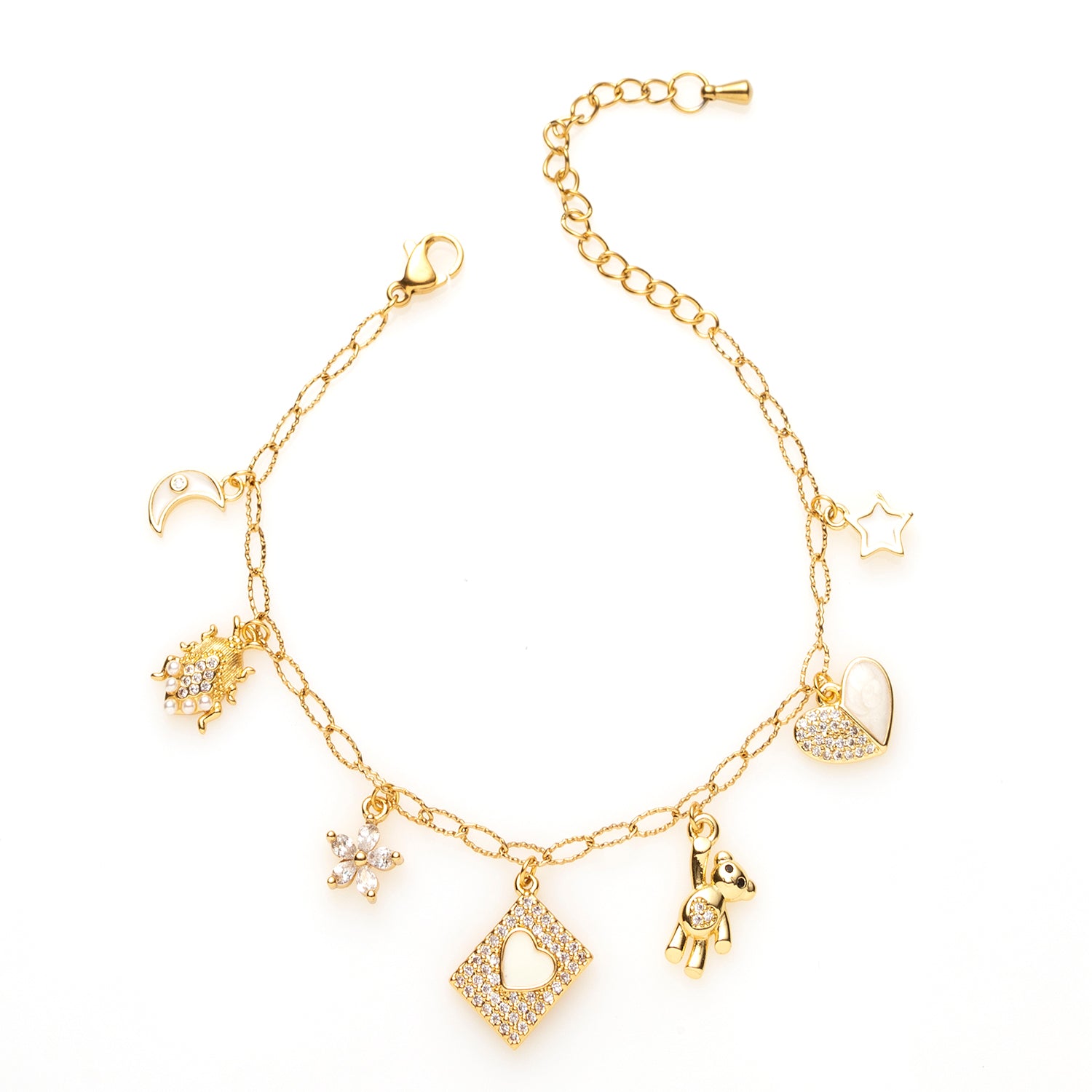 Droom weg met Sweet Dreams, een betoverende bedelarmband waarin speelsheid, symboliek en elegantie samenkomen. Deze gouden armband is versierd met fijne witte bedels die elk hun eigen verhaal vertellen: een maantje voor nachtelijke dromen, een kever als geluksbrenger, een bloem als symbool voor groei, een mini-boekje voor jouw mooiste herinneringen, een schattig beertje voor zachtheid, een hartje voor liefde en een ster die staat voor hoop en licht.