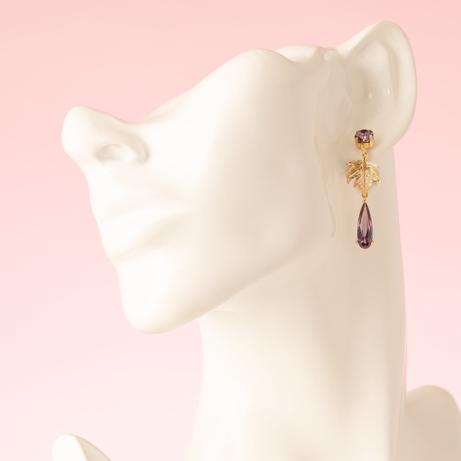 Laat je betoveren door de natuurlijke elegantie van de Lavender Garden asymmetrische oorbellen. De oorbel heeft paarse Swarovski oorstekers, een paars zirkonia tussenstuk en een delicate bloem, waaraan een paarse libelle gracieus hangt. De andere oorbel is voorzien van een gouden blaadje met zirkonia steentjes en een paarse druppel, wat het asymmetrische ontwerp extra speels en verfijnd maakt. Perfect voor een etentje, een feestje of een speciale gelegenheid, en een subtiel statement dat je vrouwelijke en e
