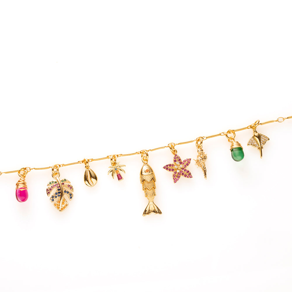 Coastal Dream neemt je mee naar zonovergoten stranden en een azuurblauwe zee. Deze elegante gouden bedelketting is rijk gevuld met zomerse bedels, waaronder een palmboom, palmblad, visje, zeester, schelp en een sierlijke rog. De fuchsia en groene glasbedels geven de ketting een frisse, kleurrijke uitstraling, terwijl de fonkelende zirkonia steentjes zorgen voor een luxe sparkle.
Een unieke eyecatcher die speels en elegant perfect combineert. Draag Coastal Dream als herinnering aan lange zomerdagen, een ont