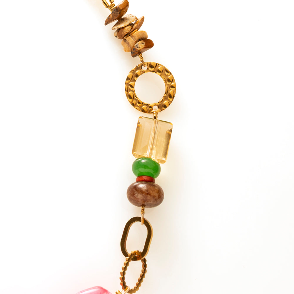 Fuchsia Fusion is een uitgesproken statement ketting waarin kleur, textuur en karakter samenkomen. De grote, glanzende acrylkralen in levendig fuchsia vormen het krachtige middelpunt en geven direct energie aan je look.
De combinatie met natuursteen kralen in warme aardetinten en frisgroen zorgt voor balans en diepte. Subtiele facetkralen vangen het licht en voegen een verfijnde sparkle toe. De diverse goudkleurige metalen elementen, van speelse ringen tot stoere schakels, geven de ketting een eigentijdse,