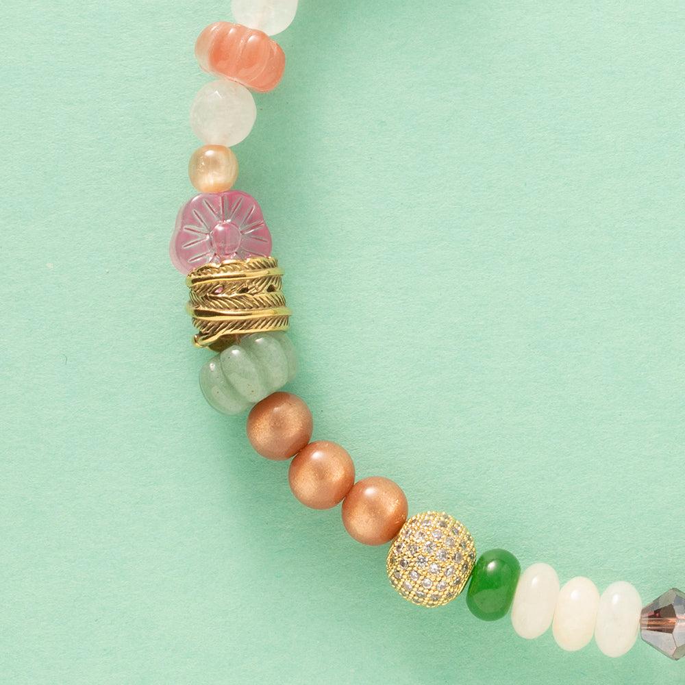 Laat je meevoeren in een dromerige zomerwereld met Wildflower Dreams, een handgemaakte statement ketting in kleurrijke boho-stijl. Deze unieke ketting combineert grote natuursteen kralen, fonkelende zirkonia’s en glaskralen in warme tinten zoals groen, warm oranje, paars, roze en wit. De combinatie van natuurlijke materialen en sprankelende accenten geeft deze ketting een speelse én elegante uitstraling.