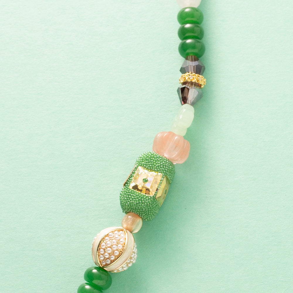 Laat je meevoeren in een dromerige zomerwereld met Wildflower Dreams, een handgemaakte statement ketting in kleurrijke boho-stijl. Deze unieke ketting combineert grote natuursteen kralen, fonkelende zirkonia’s en glaskralen in warme tinten zoals groen, warm oranje, paars, roze en wit. De combinatie van natuurlijke materialen en sprankelende accenten geeft deze ketting een speelse én elegante uitstraling.