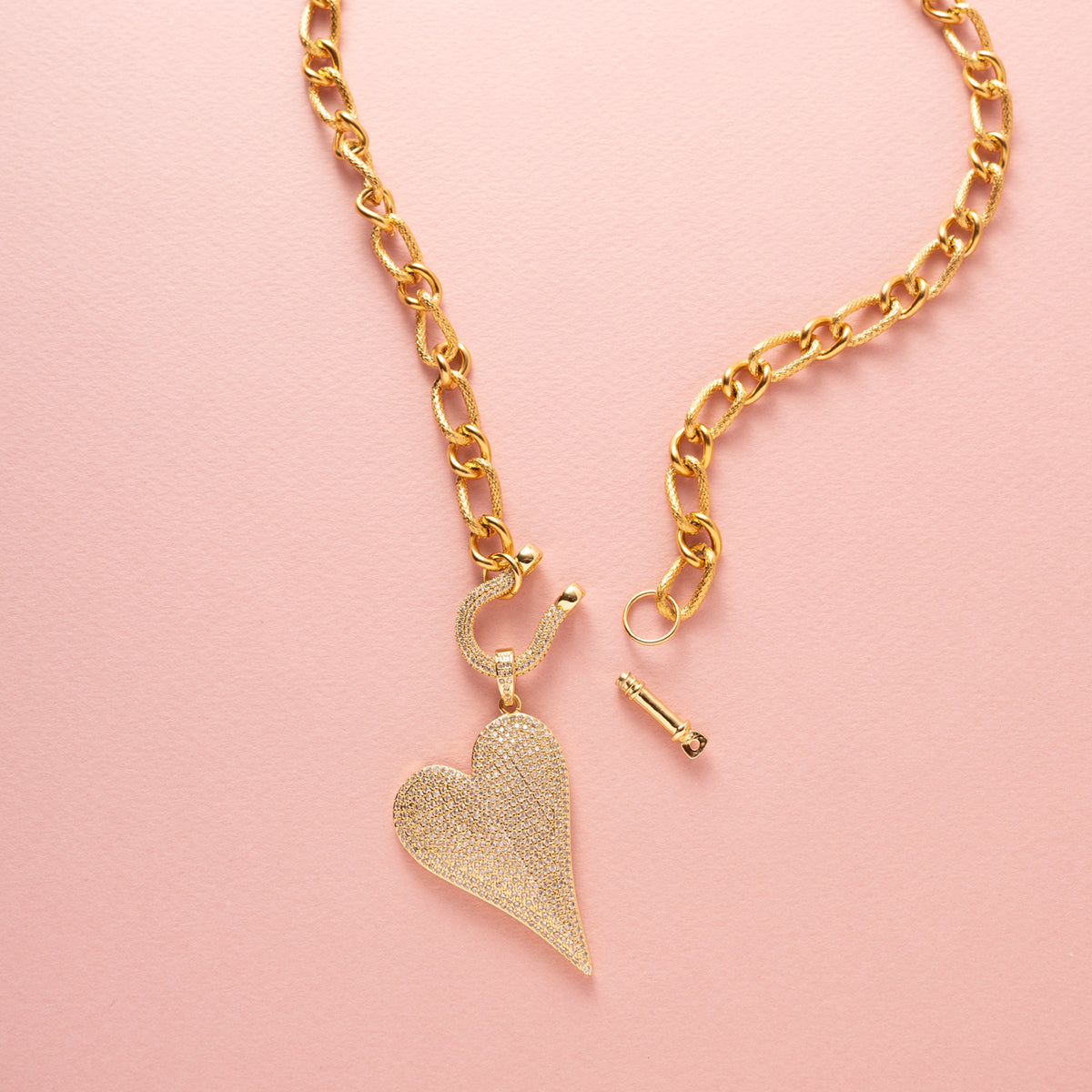 Maak een krachtig statement met de Heart of Sparkle Statement ketting. Deze opvallende ketting heeft een grove schakel en een groot zirkonia hart als eye catcher, waardoor het de perfecte aanvulling is op elke outfit. Het bijzondere slotje maakt het mogelijk om verschillende bedels aan de ketting toe te voegen, waardoor je de mogelijkheid hebt om je look te personaliseren. Dit veelzijdige sieraad is een prachtig statement piece.