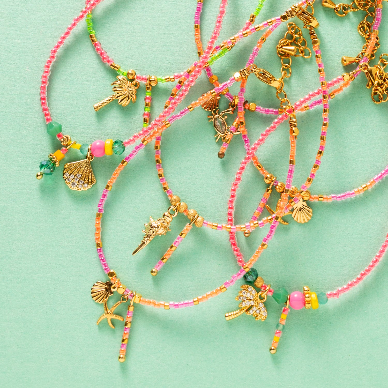 Dit handgemaakte kralenarmbandje in paars en fel oranje Toho-kralen is een ware blikvanger! Het wordt prachtig aangevuld met bedeltjes van een zeester en schelpje, die een speelse, tropische flair toevoegen.