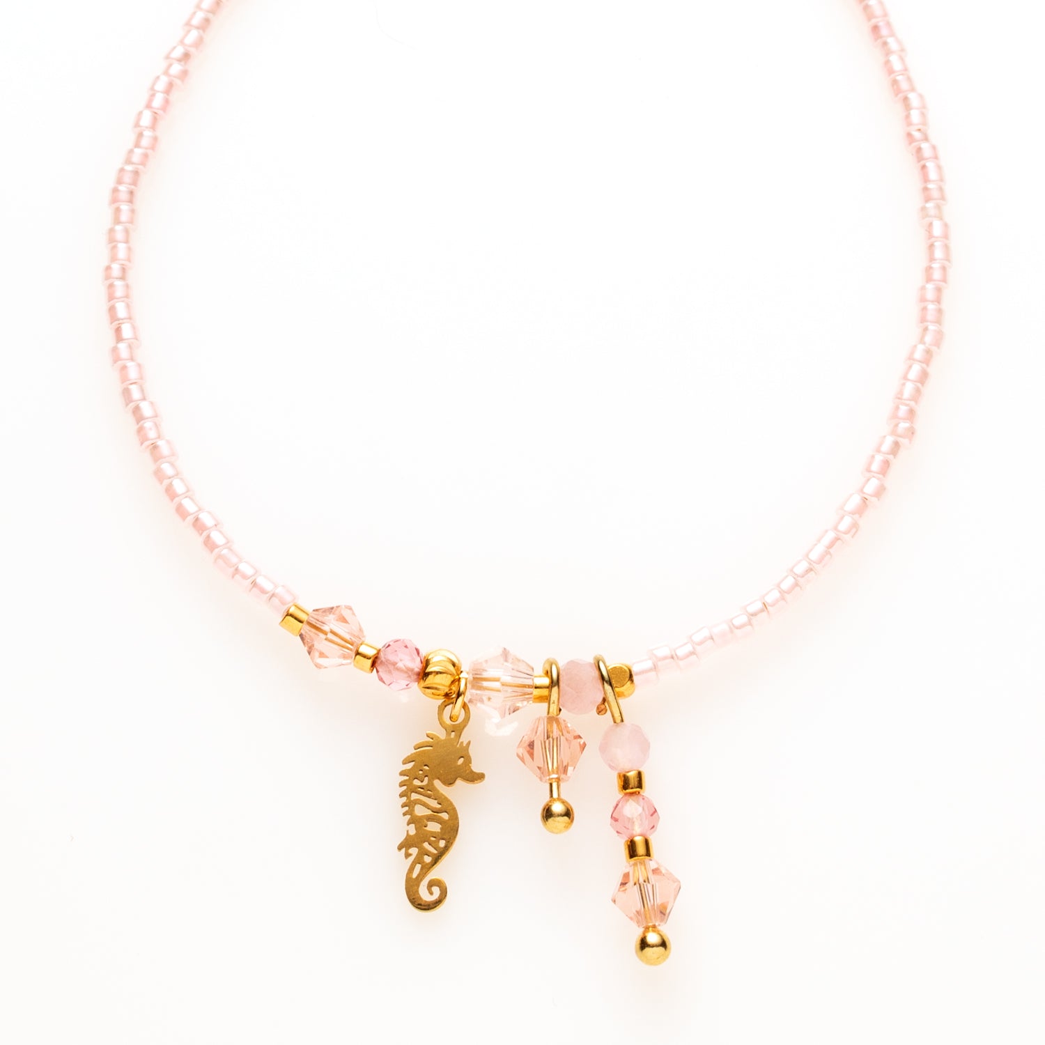 Een verfijnd en subtiel armbandje dat de schoonheid van eenvoud benadrukt. Dit delicate armbandje is gemaakt van lichtroze Toho-kralen, die een zachte en elegante uitstraling geven. Het schattige zeepaardje-bedeltje voegt een speels en tropisch element toe, perfect voor een zomerse, boho look.