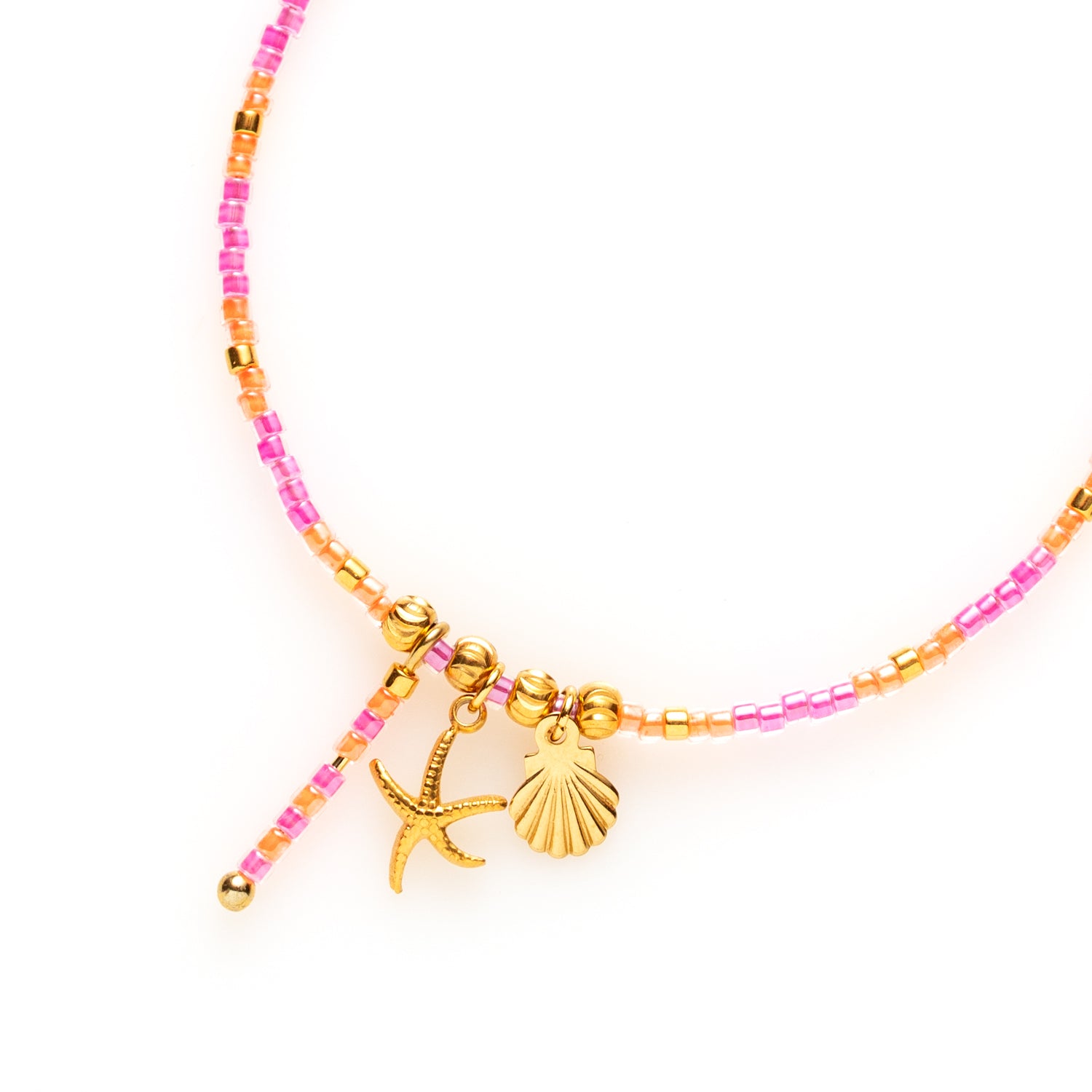 Dit handgemaakte kralenarmbandje in paars en fel oranje Toho-kralen is een ware blikvanger! Het wordt prachtig aangevuld met bedeltjes van een zeester en schelpje, die een speelse, tropische flair toevoegen.