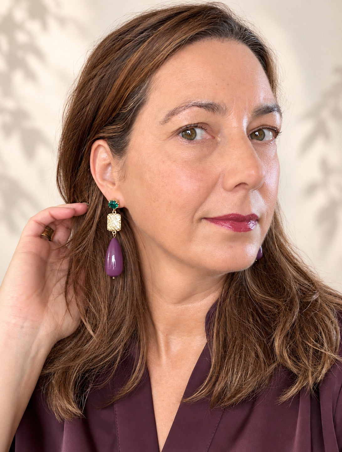 Een diepe aubergine druppel naast een smaragdgroen Swarovski kristal: een kleurcombinatie die opvalt zonder te schreeuwen. Het goudkleurige tussenstuk, bezet met zirkonia, vangt het licht bij elke beweging De gladde, glanzende druppel en de fonkelende steentjes maken deze oorbellen tegelijk verfijnd en krachtig.
Groot in formaat, rustig in kleur: verfijnd genoeg voor kantoor, opvallend genoeg voor een avondje uit.