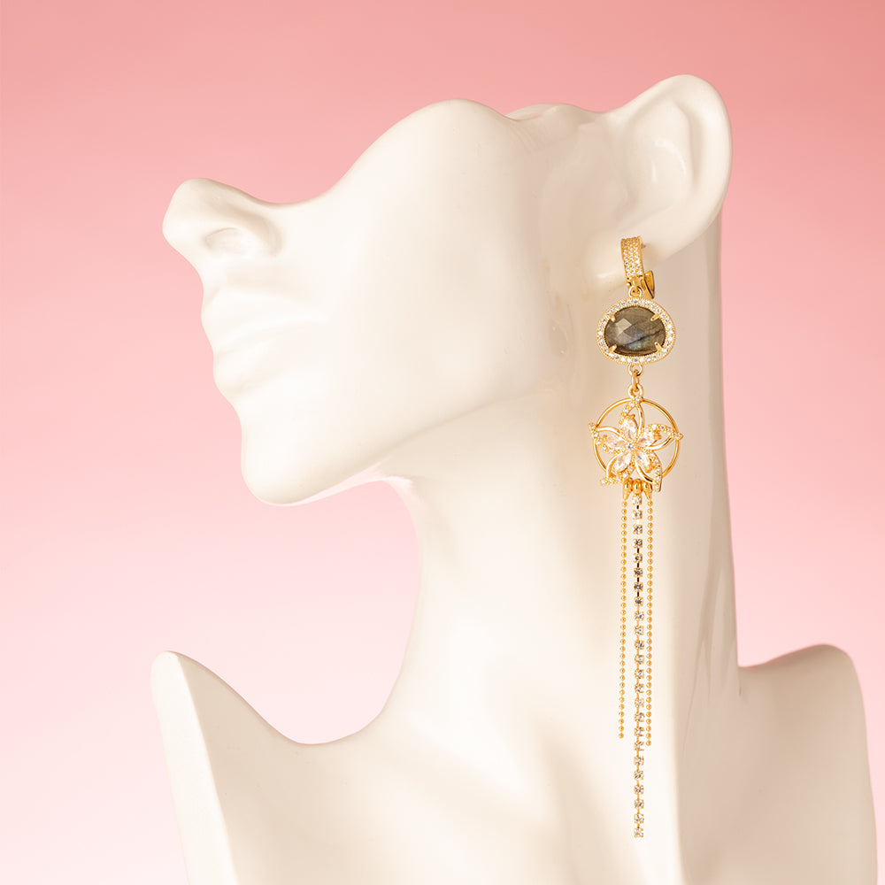 lange, elegante oorbellen zijn de perfecte mix van verfijning en glamour. De natuursteen spectroliet, met zijn betoverende kleurveranderingen en mysterieuze glans, vormt het opvallende middelpunt van de oorbellen. De schitterende zirkonia bloem voegt een vleugje sprankeling en verfijning toe, waardoor deze oorbellen niet alleen stijlvol, maar ook tijdloos zijn. Ze zijn lang, elegant en trekken de aandacht.