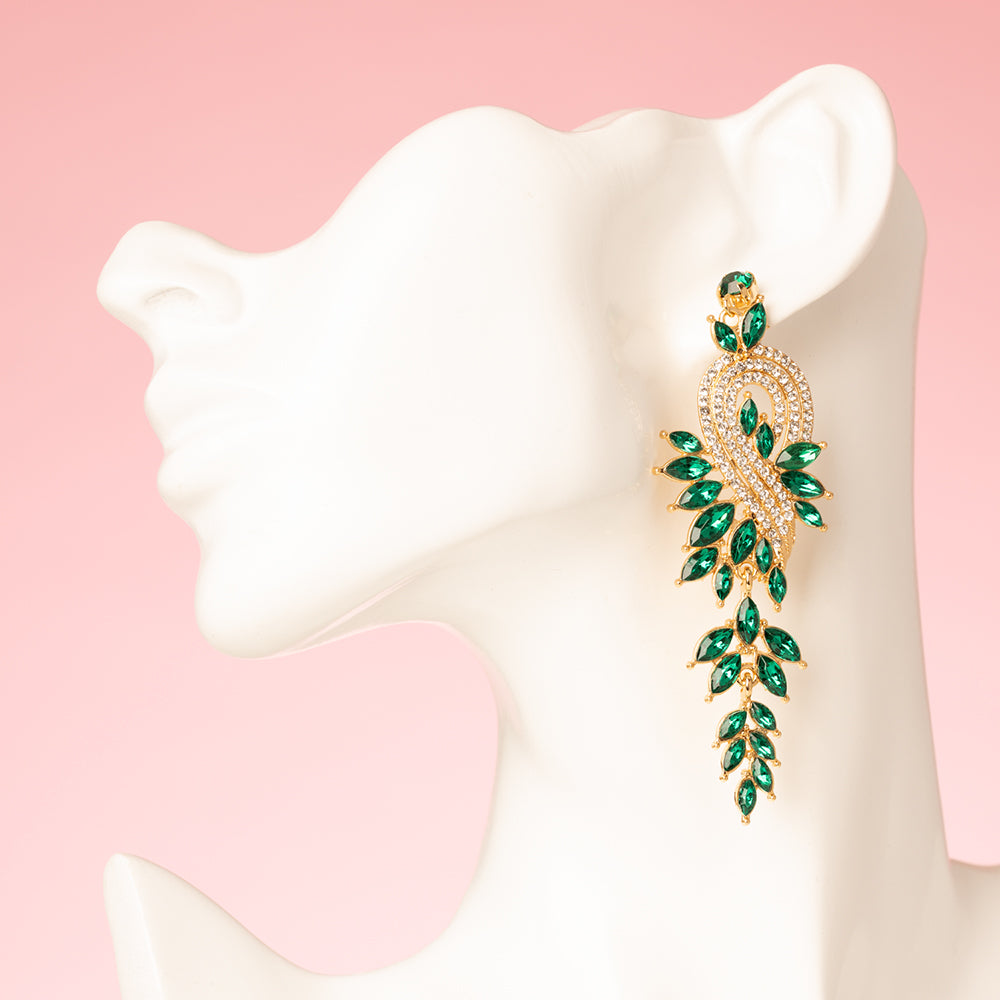 Voor de vrouw die durft te stralen. Emerald Allure zijn lange, opvallende oorbellen vol fonkelende groene stenen die elke blik vangen. Elegant, gedurfd en perfect voor feestelijke avonden, van kerstborrels tot sprankelende diners. Deze oorbellen zijn echte eyecatchers en geven iedere outfit een instant glamour upgrade.