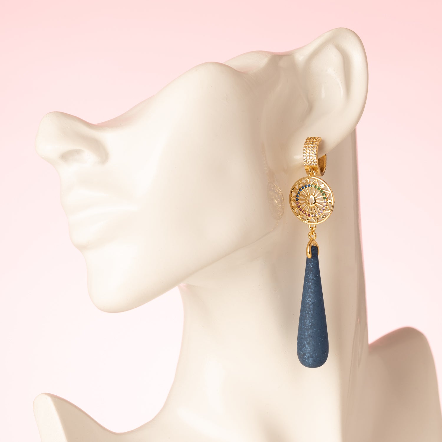 Celestial Blue is een oogstrelende oorbel die glamour en kleur samenbrengt. De zirkonia oorringen verbinden zich met een rond tussenstuk, versierd met fonkelende zirkonia steentjes in verschillende kleuren. Daaronder hangen matte Polaris druppels in royal blue met subtiele glitters, die elke beweging een sprankelende, bijna magische touch geven.
Een perfecte oorbel voor vrouwen die durven te stralen met elegantie en kleur, van dag tot avond.