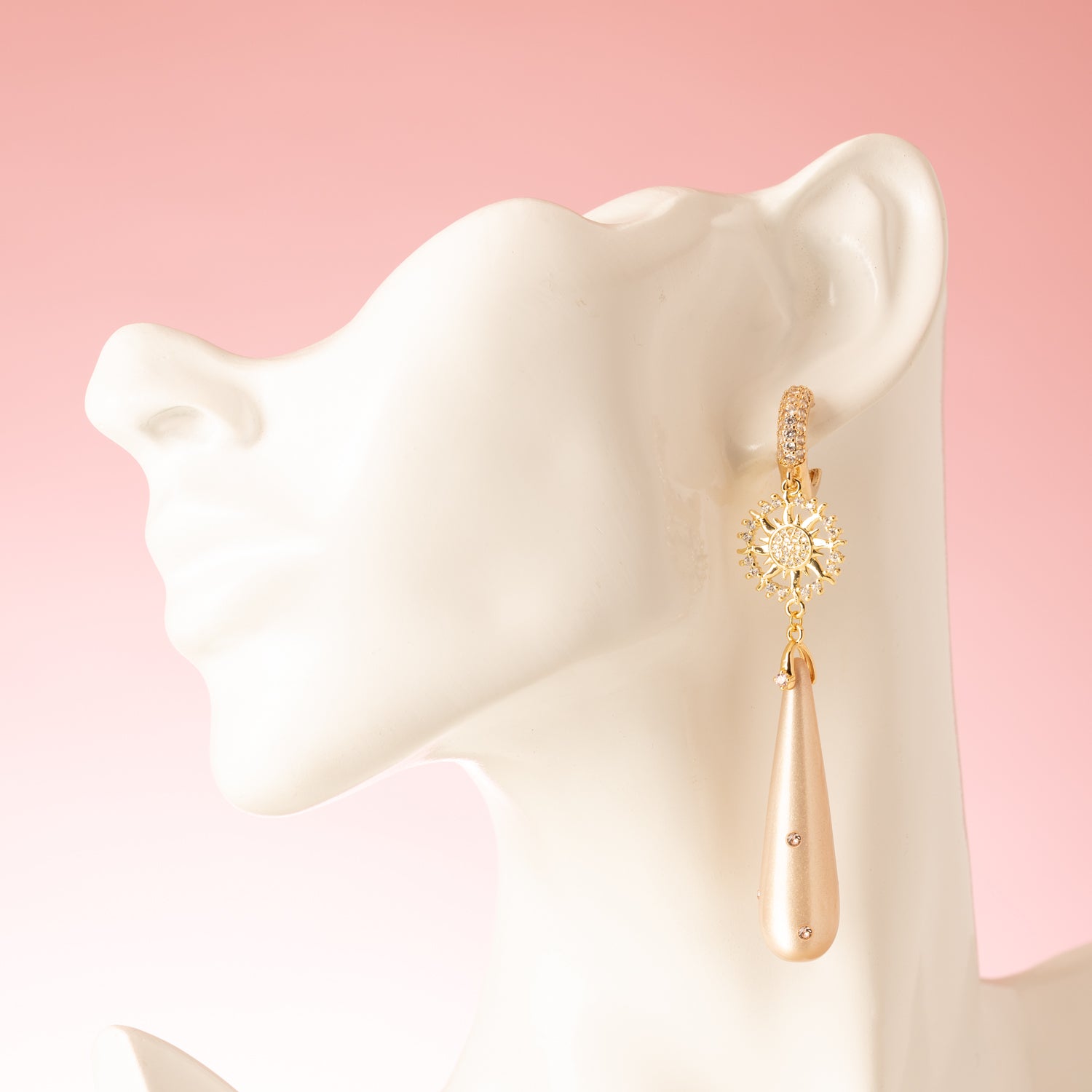 Voeg een vleugje zachte schittering toe aan je look met Rosy Luminance. Deze elegante oorbellen combineren een zacht roze polaris druppel met verfijnde roze Swarovski steentjes die een subtiel sprankelend accent geven.
Het zirkonia zon-tussenstuk brengt een stijlvolle, stralende touch die mooi contrasteert met de zachte tinten van de druppel. De zirkonia oorringen maken het geheel af met een tijdloze luxe die past van kantoor tot avond.