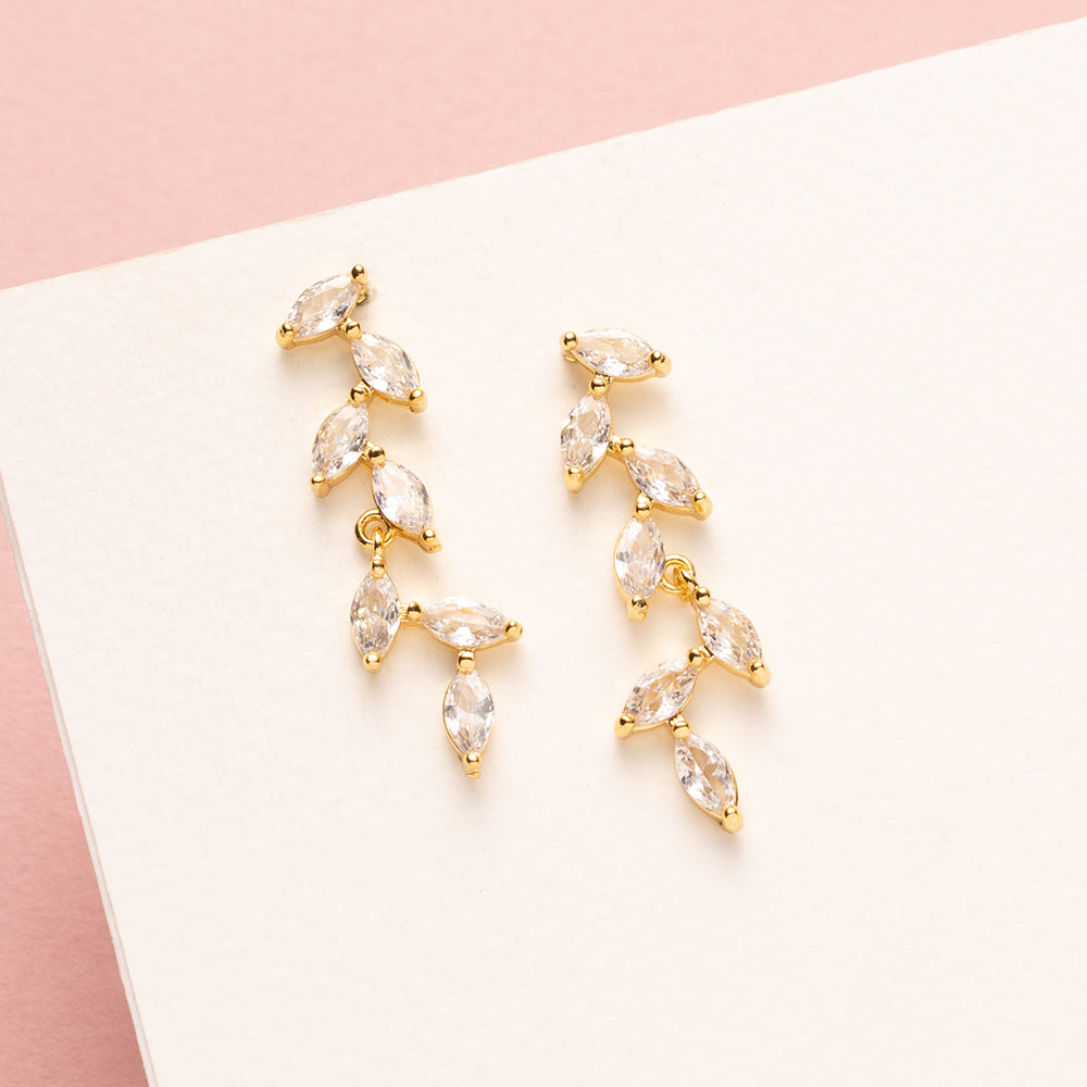 elegante zirkonia oorbellen met sierlijke blaadjes stralen tijdloze verfijning uit. Het subtiele ontwerp en de glinsterende steentjes geven een chic accent dat bij elke gelegenheid past. De oorbellen bewegen gracieus en vangen het licht op een manier die de illusie van dwarrelende blaadjes creëert