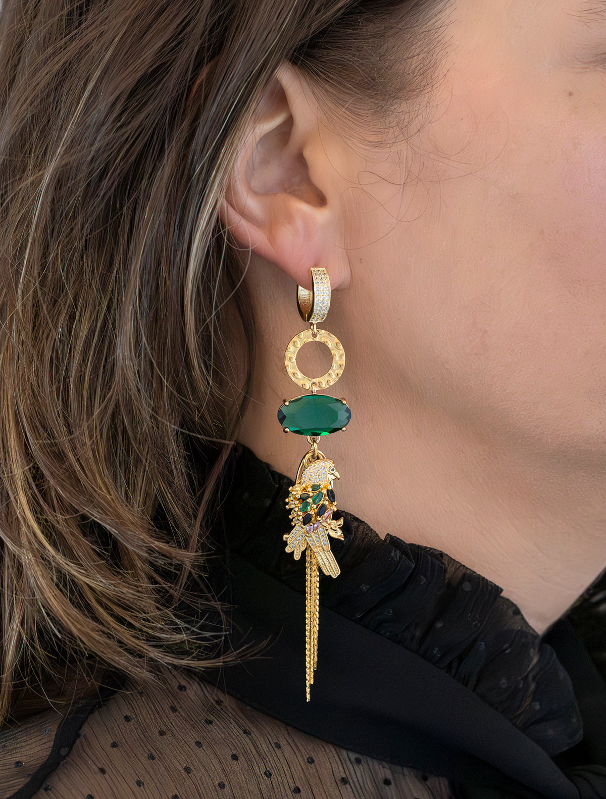Breng de tropische vibes tot leven met deze asymmetrische statement oorbellen. Een kleurrijke papegaai met sprankelende groene stenen siert de ene kant, terwijl een sierlijk palmblad de andere kant compleet maakt. Groot, opvallend en speels – perfect voor een exotische en gedurfde uitstraling.