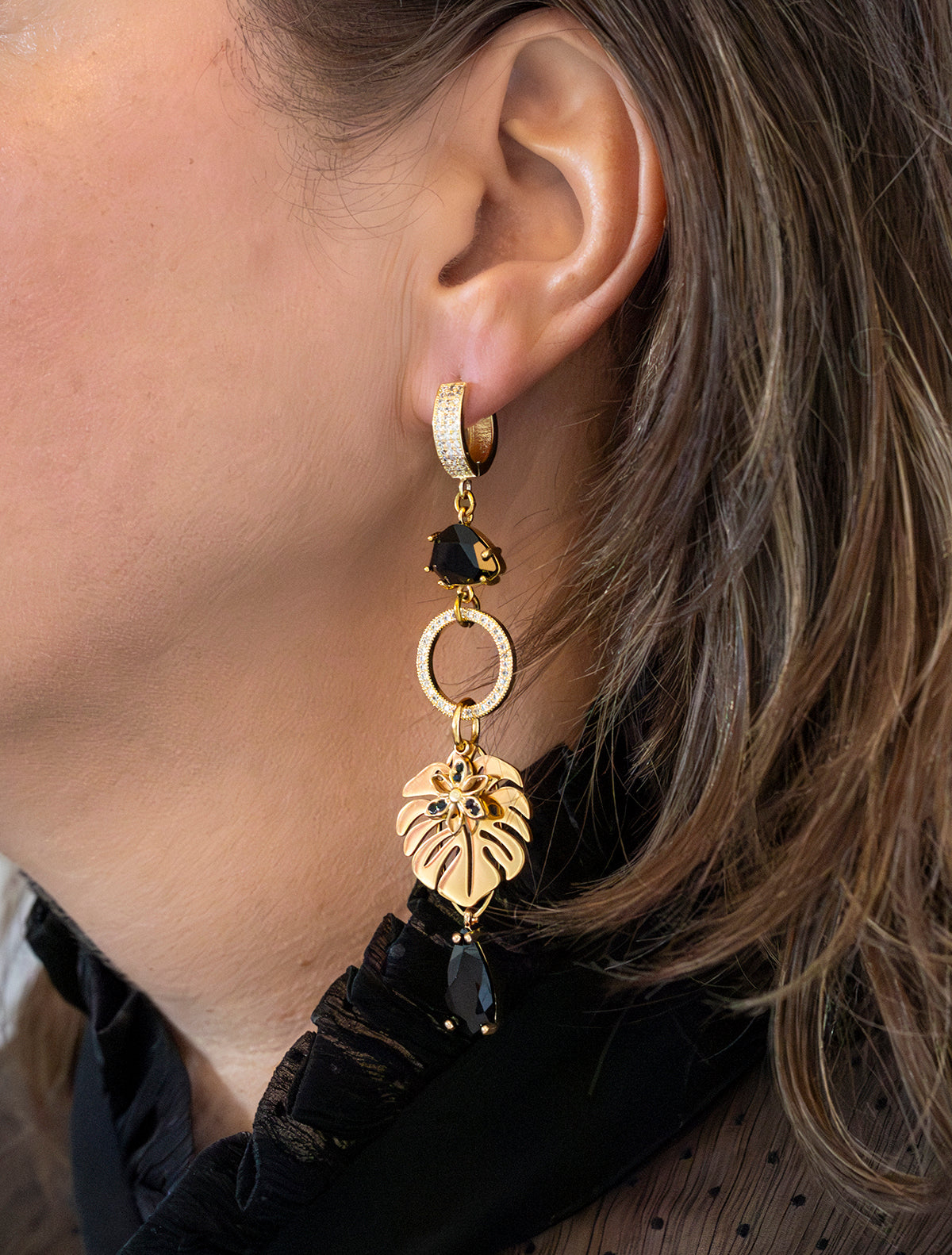 Laat je meevoeren naar de mysterieuze nachtelijke jungle met deze asymmetrische  oorbellen. Aan de ene kant schittert een elegante papegaai met diepzwarte stenen, terwijl de andere kant wordt gesierd door een stijlvol palmblad. Groot, opvallend en speels – perfect voor wie durft te stralen met een uniek design.