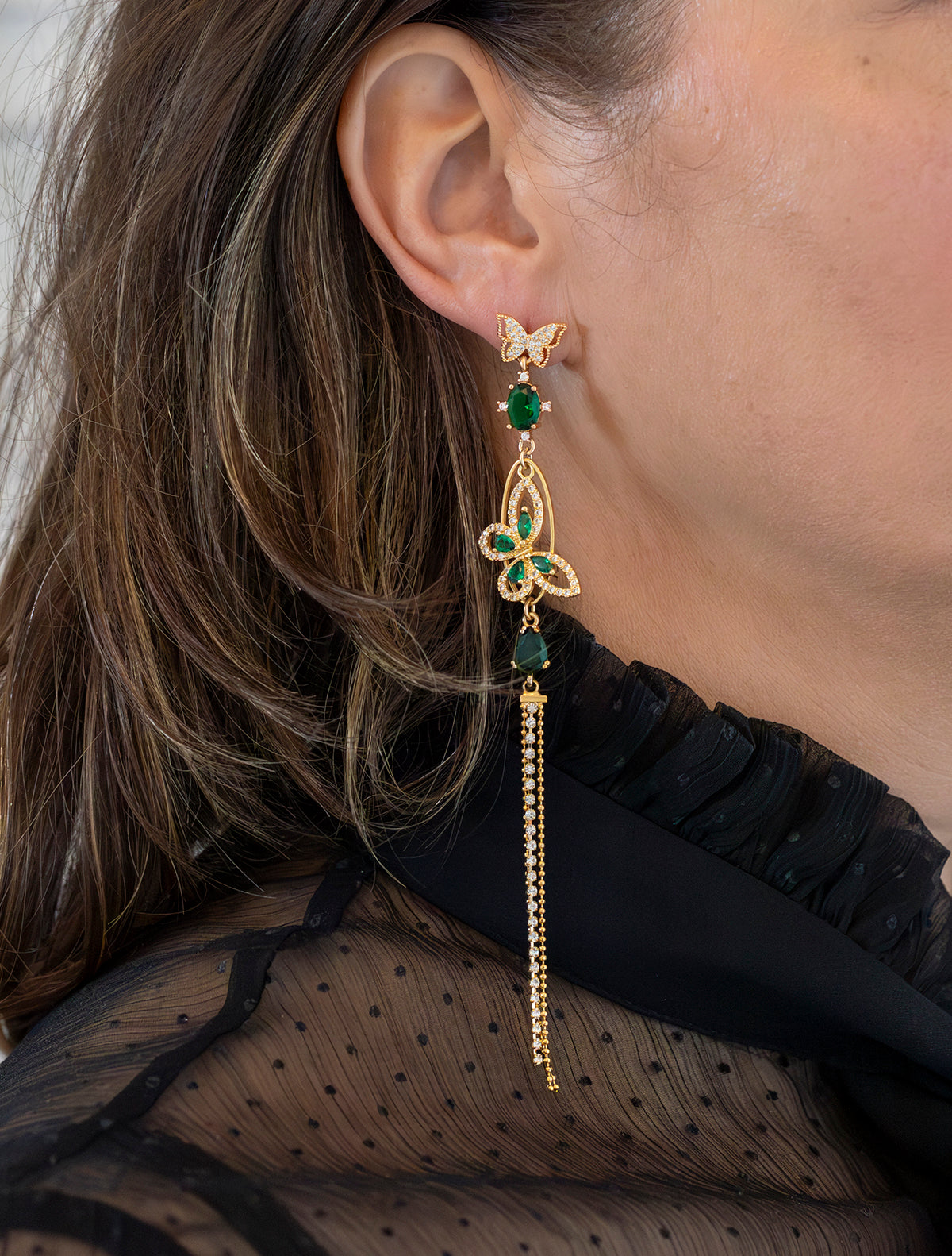 Asymmetrische Statement Oorbellen met zirkonia vlinder stekers. Diverse groen zirkonia en crystal glas stenen. En een groene vlinder