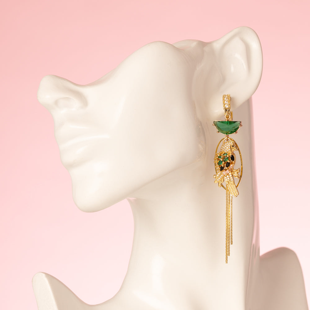 Asymmetrische statement oorbellen met een papegaai en een monstera blad. Met zirkonia oorringen en zirkonia bedels in de kleuren goud en groen