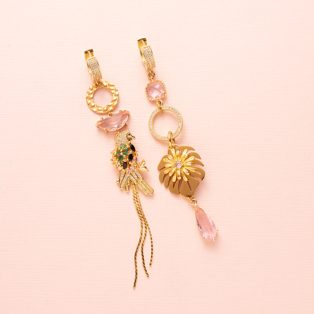 Voeg een vleugje fun & flair toe aan je look met deze asymmetrische statement oorbellen. Een speelse papegaai met sprankelende roze stenen siert de ene kant, terwijl een sierlijk palmblad de andere kant compleet maakt. Lief, vrolijk en tropisch – perfect voor een frisse en opvallende uitstraling! 