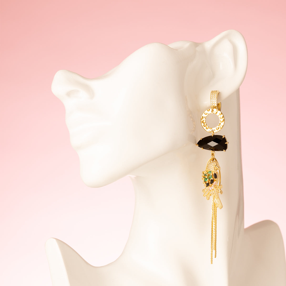 Laat je meevoeren naar de mysterieuze nachtelijke jungle met deze asymmetrische  oorbellen. Aan de ene kant schittert een elegante papegaai met diepzwarte stenen, terwijl de andere kant wordt gesierd door een stijlvol palmblad. Groot, opvallend en speels – perfect voor wie durft te stralen met een uniek design.