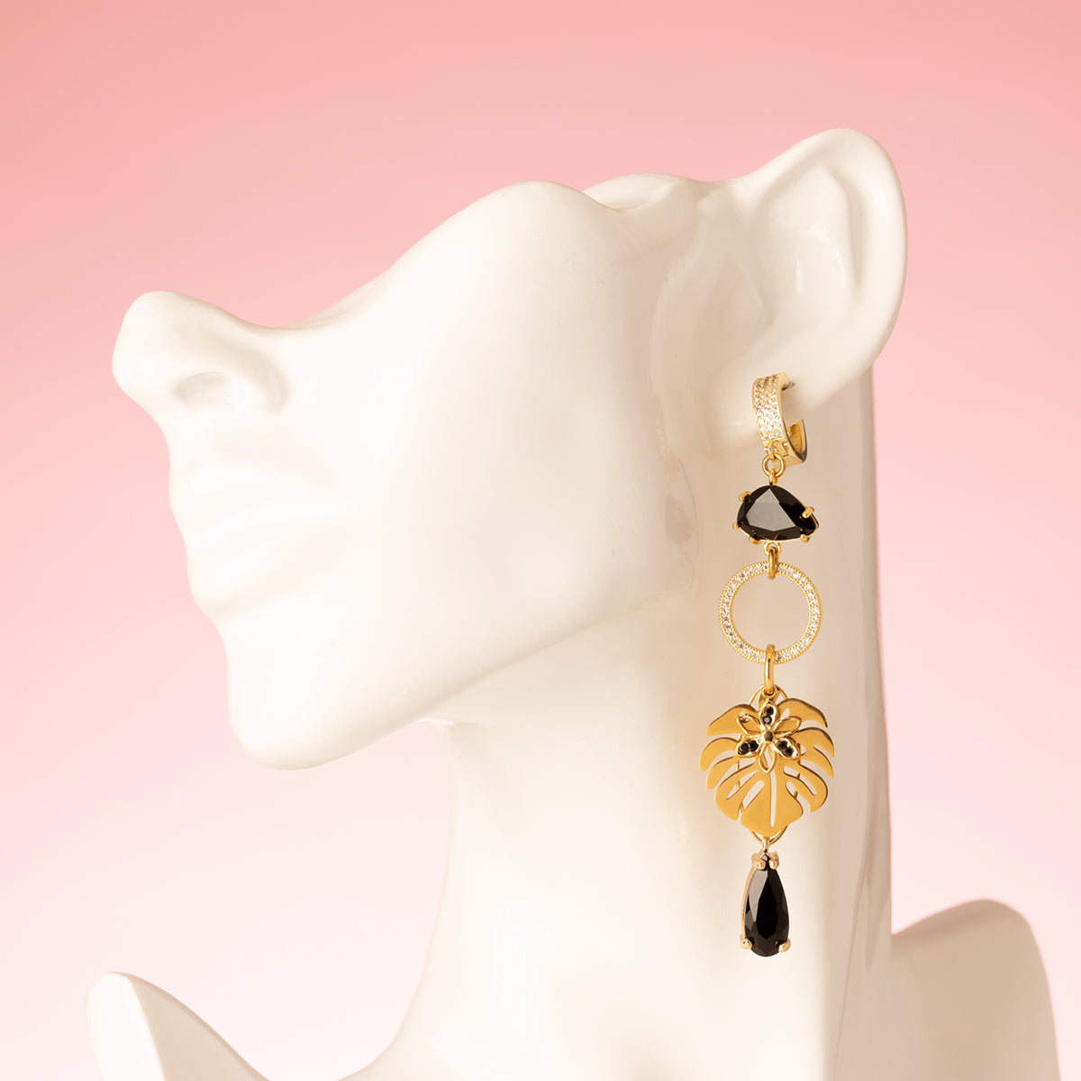 Laat je meevoeren naar de mysterieuze nachtelijke jungle met deze asymmetrische  oorbellen. Aan de ene kant schittert een elegante papegaai met diepzwarte stenen, terwijl de andere kant wordt gesierd door een stijlvol palmblad. Groot, opvallend en speels – perfect voor wie durft te stralen met een uniek design.