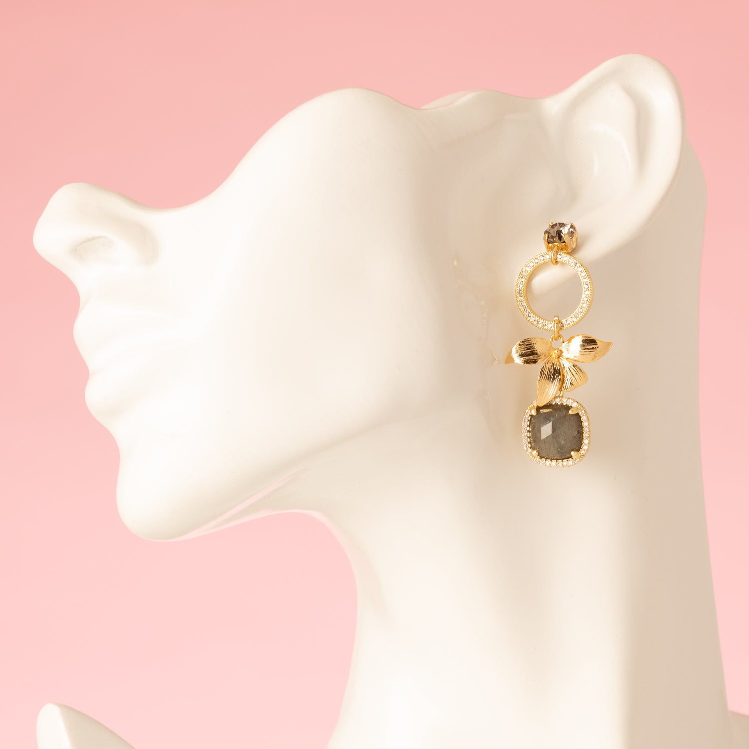 Voeg een subtiel en verfijnd accent toe met de Aurora Bloom asymmetrische oorbellen. De oorbellen hebben een fonkelende Swarovski oorsteker, een gouden bloem, sprankelende zirkonia cirkels en een prachtige spectrolite edelsteen die een zacht kleurenspel laat zien bij iedere beweging. Het asymmetrische ontwerp geeft een speels, elegant karakter en maakt deze oorbellen perfect voor een etentje, een speciale gelegenheid of om je dagelijkse look een verfijnde touch te geven.