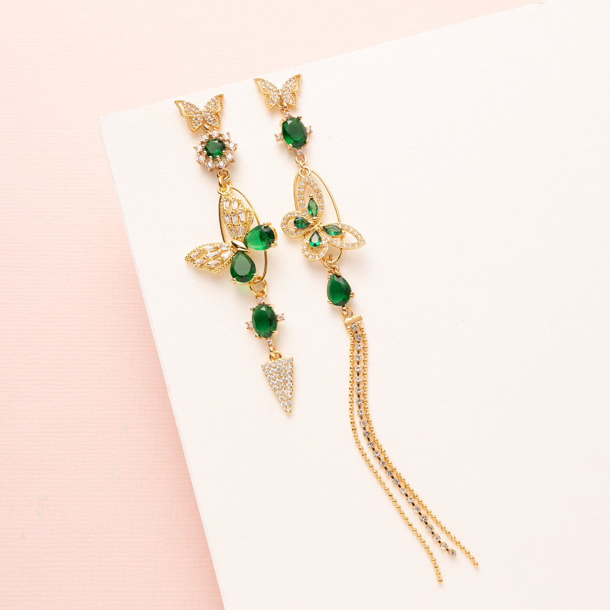 Asymmetrische Statement Oorbellen met zirkonia vlinder stekers. Diverse groen zirkonia en crystal glas stenen. En een groen vlinder