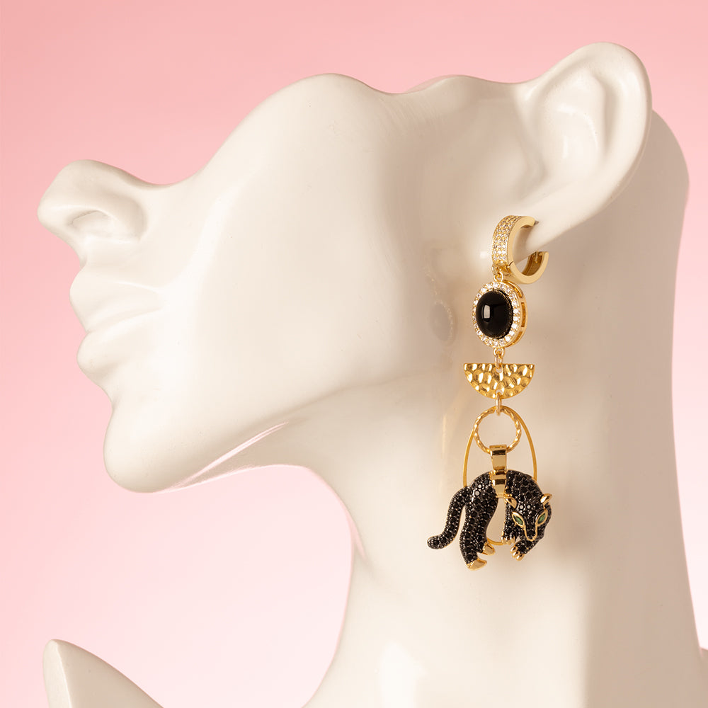 Gouden Asymmetrische, sluitbare zirkonia Statement Oorbellen met een zwarte panter en een tandbedel. Met zirkonia en crystal glas.