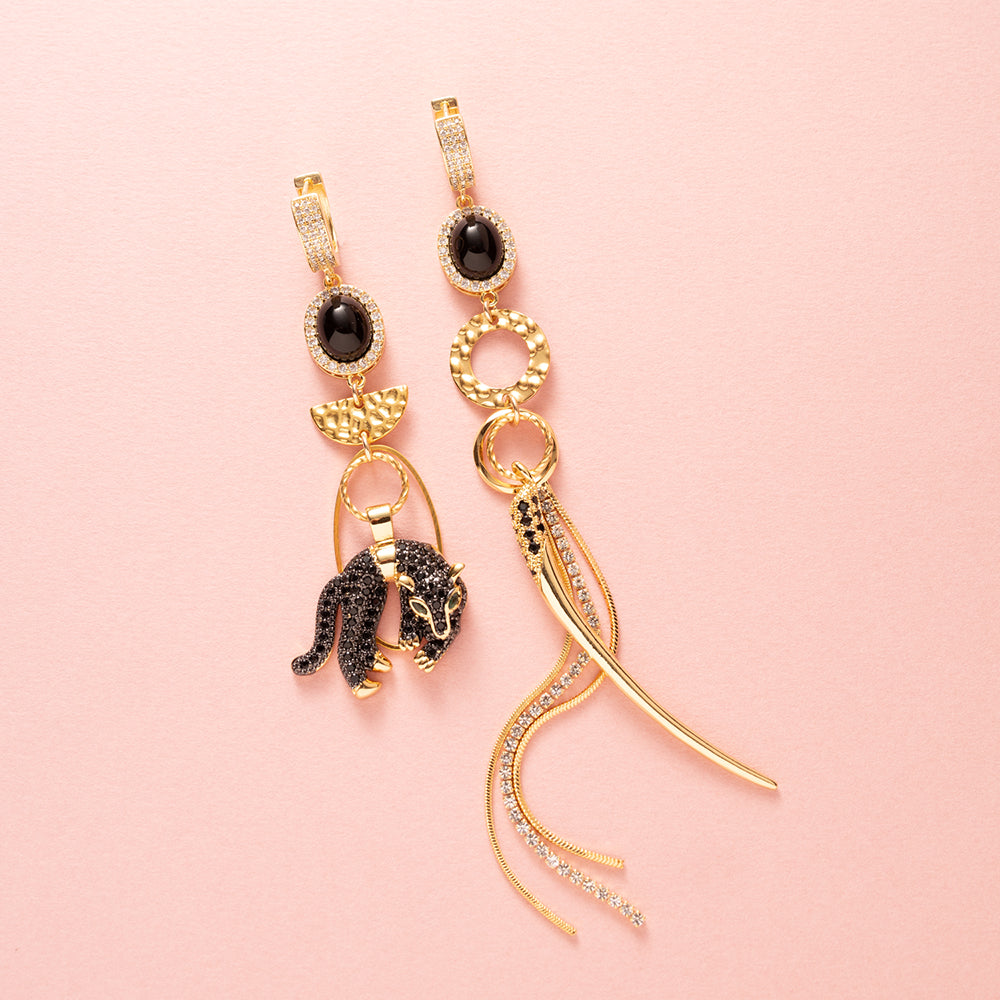 Gouden Asymmetrische, sluitbare zirkonia Statement Oorbellen met een zwarte panter en een tandbedel. Met zirkonia en crystal glas.
