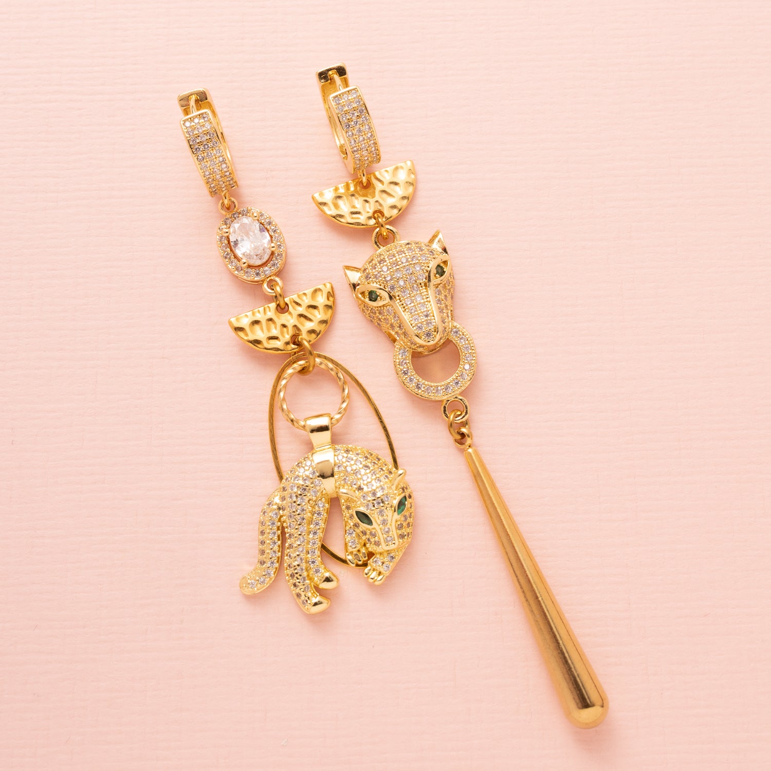 Asymmetrische statement oorbellen in goud met 2 zirkonia panters. Groot en opvallend. Stoer en chique.