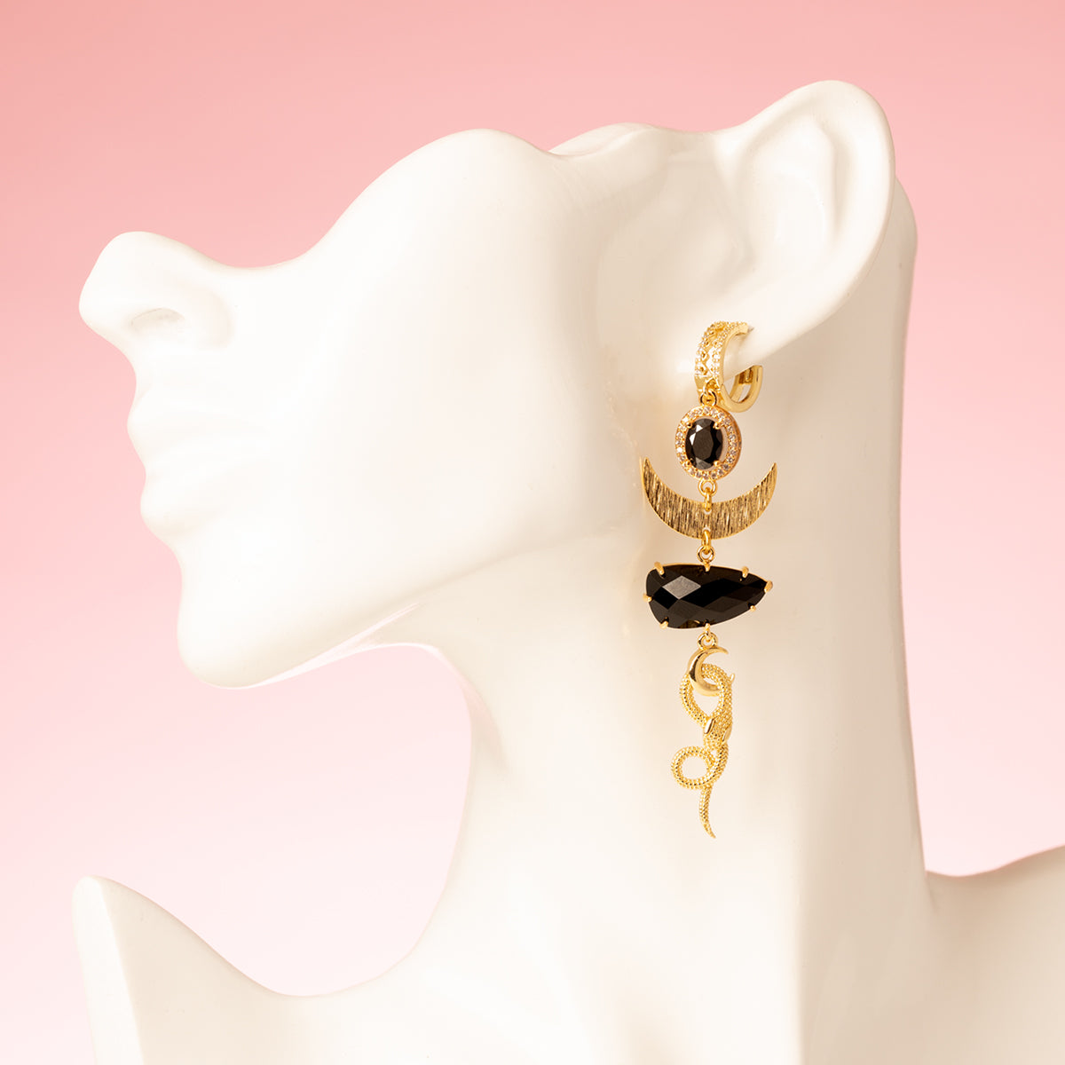 Deze asymmetrische statement oorbellen combineren mysterie en luxe in een gedurfd ontwerp. Met diepzwarte stenen die het licht op subtiele wijze vangen, en een sierlijke slang – het ultieme symbool van transformatie en kracht. De combinatie van stoer en elegant maakt deze oorbellen perfect voor vrouwen die durven opvallen. Een edgy eye-catcher die elke look naar een hoger niveau tilt! 