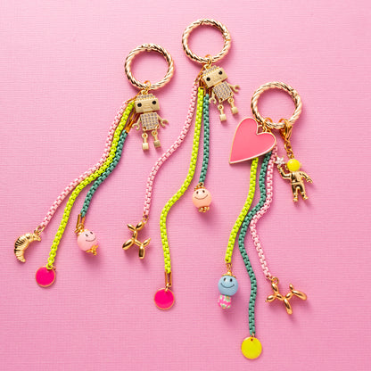 Geef je tas een speelse upgrade met deze opvallende bag charm,&amp;nbsp; dé trend van dit moment waar je niet omheen kunt. Met een vrolijk robotje, een smiley en een schattig croissantje straalt deze charm pure fun en persoonlijkheid uit.

Je klikt ‘m in een handomdraai aan je tas, rugzak of sleutelbos. Perfect om jouw look nét dat beetje extra te geven. De kleurrijke combinatie en eigenzinnige details zorgen voor een instant happiness-gevoel, elke keer als je ‘m ziet bungelen.