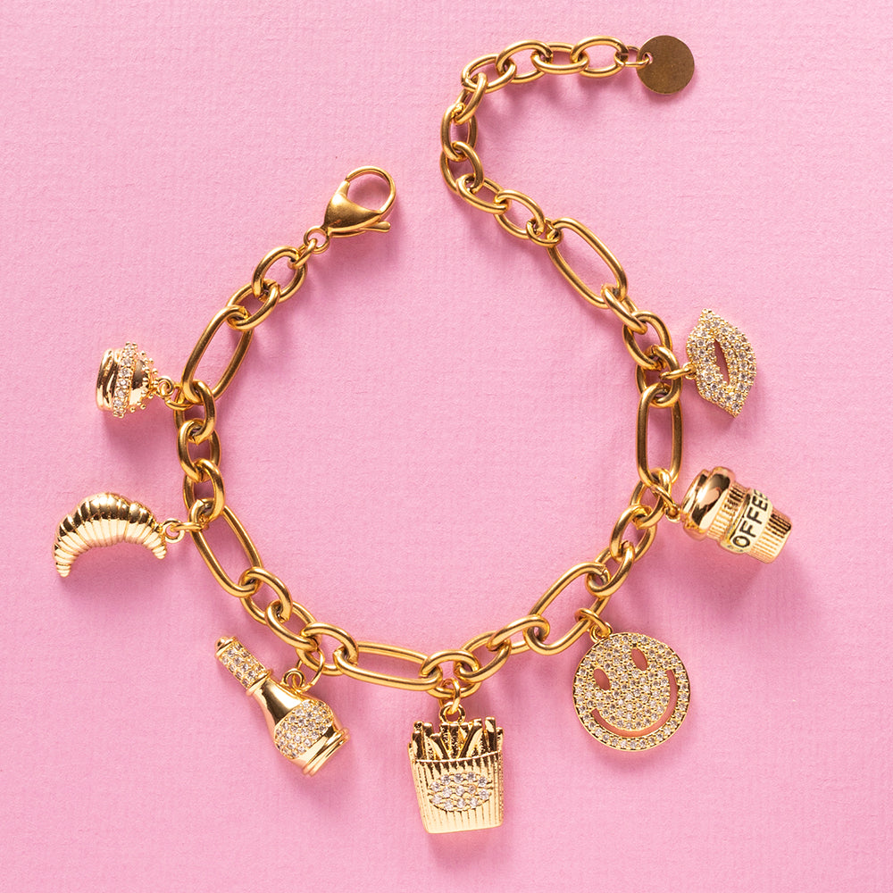Guilty Pleasure is een eigenzinnige luxe bedelarmband die draait om alles waar je stiekem blij van wordt. Van een croissant bij je koffie, een knapperige frietje, een juicy hamburger tot champagne met een glimlach en een kissable lip. Deze armband viert de kleine verleidingen van het leven.

De gouden afwerking in combinatie met fonkelende zirkonia steentjes geeft elk bedel een elegante sparkle, waardoor fun en luxe naadloos samenkomen. Een echte eyecatcher die luchtig, eigenzinnig en toch stijlvol is.