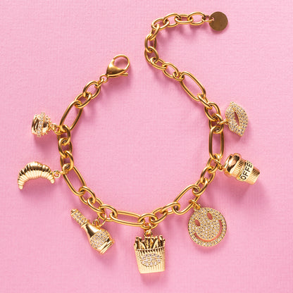 Guilty Pleasure is een eigenzinnige luxe bedelarmband die draait om alles waar je stiekem blij van wordt. Van een croissant bij je koffie, een knapperige frietje, een juicy hamburger tot champagne met een glimlach en een kissable lip. Deze armband viert de kleine verleidingen van het leven.

De gouden afwerking in combinatie met fonkelende zirkonia steentjes geeft elk bedel een elegante sparkle, waardoor fun en luxe naadloos samenkomen. Een echte eyecatcher die luchtig, eigenzinnig en toch stijlvol is.
