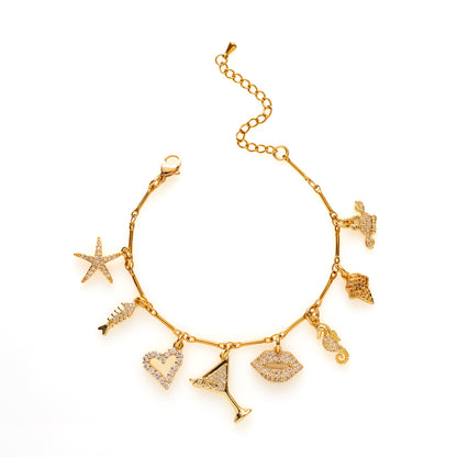 Laat de zomer maar komen met Tropical Flirt! Deze goudkleurige bedelarmband is een speelse mix van lipjes, een cocktail, ijsje, hartje, zeester en zeediertjes zoals een krab en zeepaardje. Vrolijk, flirty en afgewerkt met fonkelende zirkonia steentjes — dé ultieme armband voor zonnige dagen en zwoele avonden.