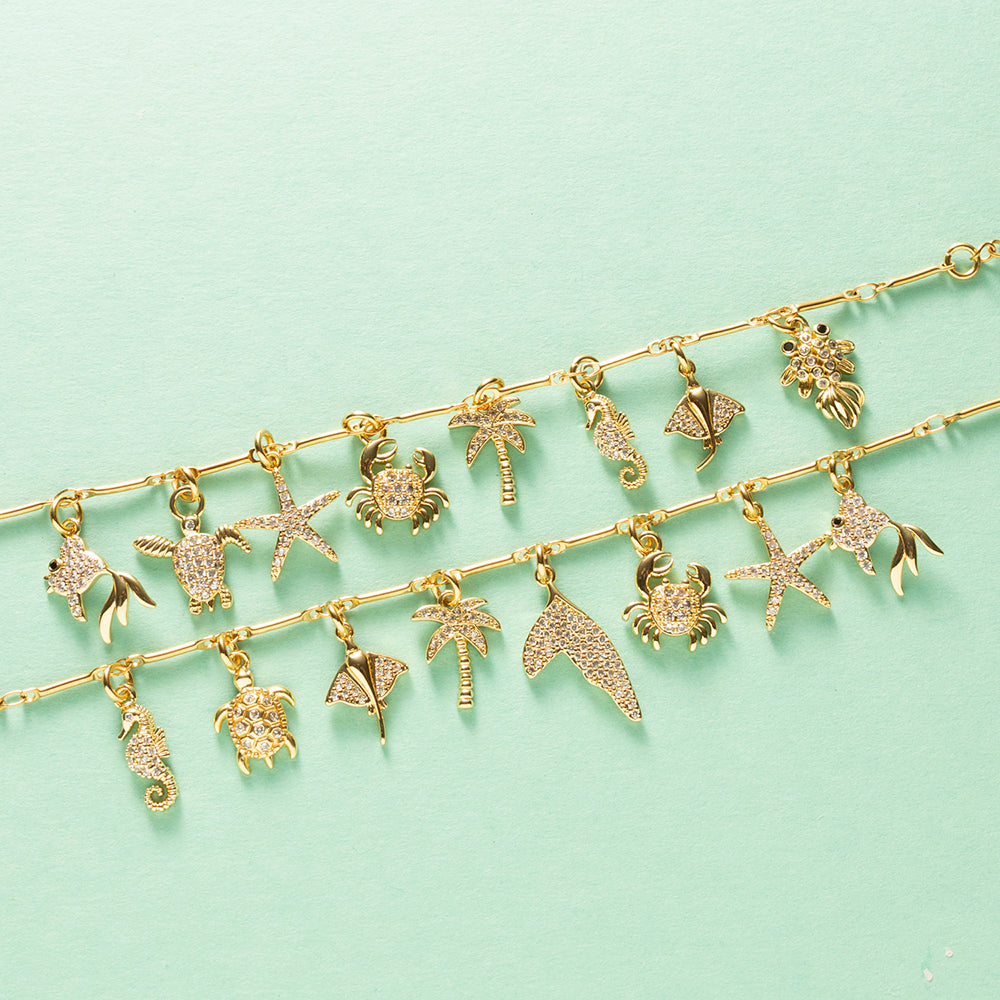 Draag de magie van de zee altijd met je mee. De Ocean Treasure Bedelarmband is een elegante armband vol verfijnde bedels met fonkelende zirkonia steentjes. Het zeepaardje, de schildpad, rog, palmboom, walvisstaart, krab, zeester en het visje vertellen samen een verhaal van zon, vrijheid en onvergetelijke zomerdagen.

Deze tijdloze bedelarmband is met liefde samengesteld en vormt een prachtig aandenken aan een bijzondere vakantie of een mooie herinnering aan de zee. Dankzij de subtiele glans en sprankelende 
