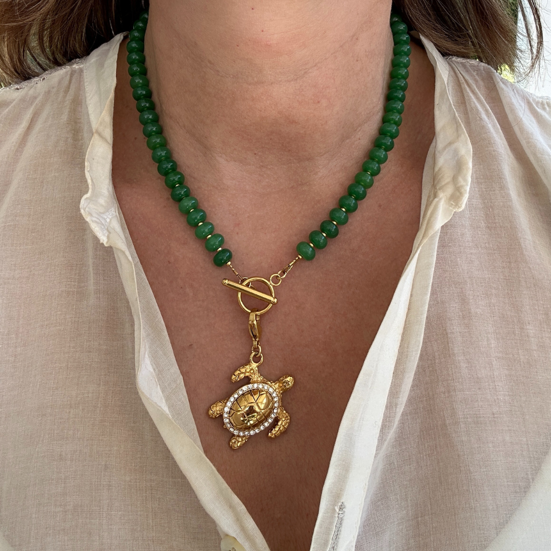 Turtle Treasure Deluxe is de ultieme eyecatcher binnen je sieradencollectie. Deze grote, opvallende schildpadbedel is rijkelijk bezet met fonkelende strass steentjes die bij elke beweging het licht vangen.

De luxe uitstraling gecombineerd met het speelse design maakt deze bedel perfect voor wie durft op te vallen. De schildpad staat symbool voor rust, bescherming en kracht. Een stijlvolle toevoeging met betekenis.

Draag ‘m als statement aan je ketting voor een unieke, persoonlijke look.
