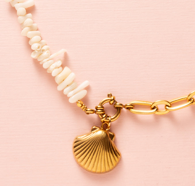 Ervaar de perfecte combinatie van elegantie en zomerse charme met de Ocean Bamboo Duo Ketting. Dit unieke sieraad bestaat uit twee delen: een zijde met natuurlijk wit Ocean Bamboo en een zijde met een grove goudkleurige schakelketting. In het midden schittert een elegant boeislot aan de voorkant, waaraan een verfijnde schelpbedel hangt.

De bedel is eenvoudig afneembaar, zodat je kunt variëren of het sieraad naar wens kunt personaliseren. 