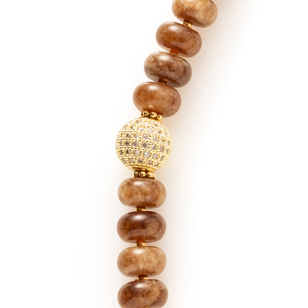 Earth Essence is een elegante natuursteen kralenketting in warme, diepe bruintinten. Deze geeft de ketting een rijke, rustige uitstraling met een verfijnd karakter.

De natuursteen kralen zorgen voor een organische, luxe look. Het opvallende zirkonia slot vormt een stijlvol middelpunt en voegt een subtiele sprankeling toe. Functioneel én decoratief, precies in balans.

Dankzij de warme aardetinten is Earth Essence moeiteloos te combineren met beige, crème, zwart en andere natuurlijke kleuren. Een tijdloos s