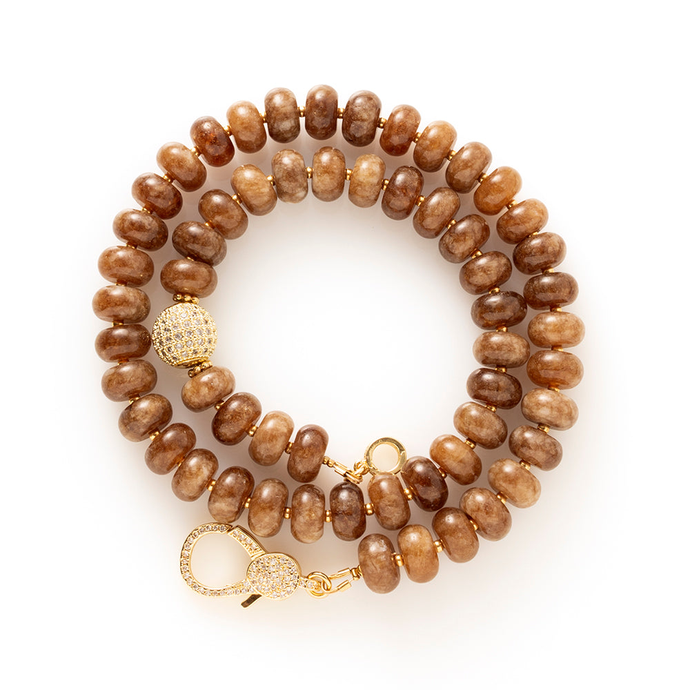 Earth Essence is een elegante natuursteen kralenketting in warme, diepe bruintinten. Deze geeft de ketting een rijke, rustige uitstraling met een verfijnd karakter.

De natuursteen kralen zorgen voor een organische, luxe look. Het opvallende zirkonia slot vormt een stijlvol middelpunt en voegt een subtiele sprankeling toe. Functioneel én decoratief, precies in balans.

Dankzij de warme aardetinten is Earth Essence moeiteloos te combineren met beige, crème, zwart en andere natuurlijke kleuren. Een tijdloos s
