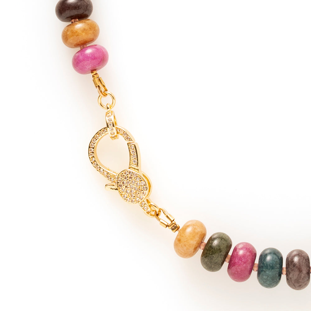 Elegante natuursteen kralenketting met rijke, diepe kleurtinten die samen een verfijnd kleurenpalet vormen. Denk aan donkermosgroen, saliegroen, blauwgrijs, warm okerbruin en een gedempte framboosroze gloed. De kleuren zijn intens maar niet fel, ze hebben een chique, volwassen uitstraling.

De zorgvuldig samengestelde natuursteen kralen geven de ketting een luxe, organische uitstraling. Het opvallende zirkonia slot vormt het stijlvolle middelpunt: subtiel sprankelend, maar krachtig genoeg om direct in het o
