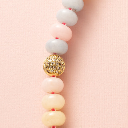 Een speelse knipoog naar de nostalgische snoepjeskettingen, maar dan modern en stijlvol. Deze ketting combineert zachte pasteltinten van Jade met levendige felroze kraaltjes voor een frisse en opvallende uitstraling. Halverwege schittert een zirkonia kraal en aan de voorkant pronkt een groot zirkonia slot, wat deze ketting tot een echte eyecatcher maakt. Perfect voor wie een kleurrijk en elegant statement wil dragen.