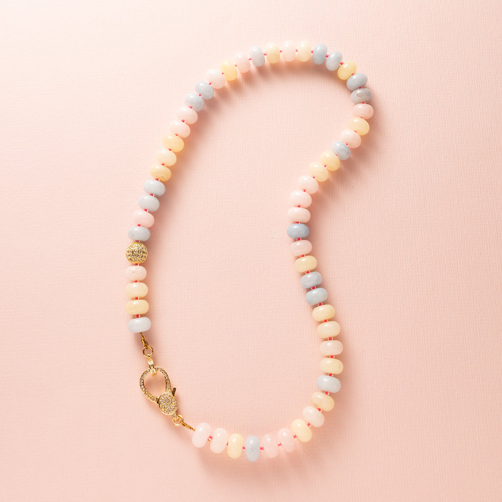 Een speelse knipoog naar de nostalgische snoepjeskettingen, maar dan modern en stijlvol. Deze ketting combineert zachte pasteltinten van Jade met levendige felroze kraaltjes voor een frisse en opvallende uitstraling. Halverwege schittert een zirkonia kraal en aan de voorkant pronkt een groot zirkonia slot, wat deze ketting tot een echte eyecatcher maakt. Perfect voor wie een kleurrijk en elegant statement wil dragen.