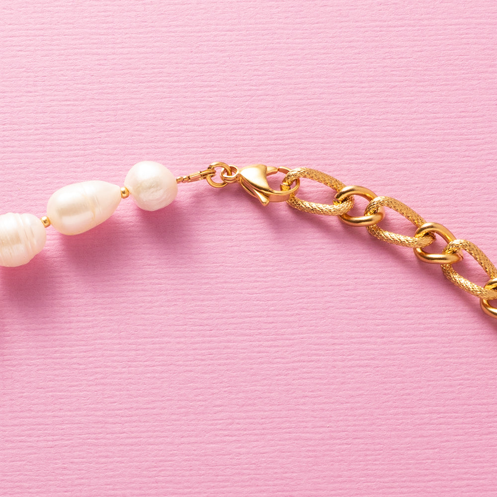 Deze moderne parelketting combineert het beste van twee werelden: de zachte elegantie van zoetwaterparels en de krachtige uitstraling van een opvallende schakel. Aan de voorkant zit een stijlvol boeislot met een zirkonia smiley die je eenvoudig kunt verwijderen. Zo wissel je moeiteloos tussen speels en puur. Een trendy maar tijdloos ontwerp dat zowel stoer als chique gedragen kan worden, passend bij elke stijl en gelegenheid.