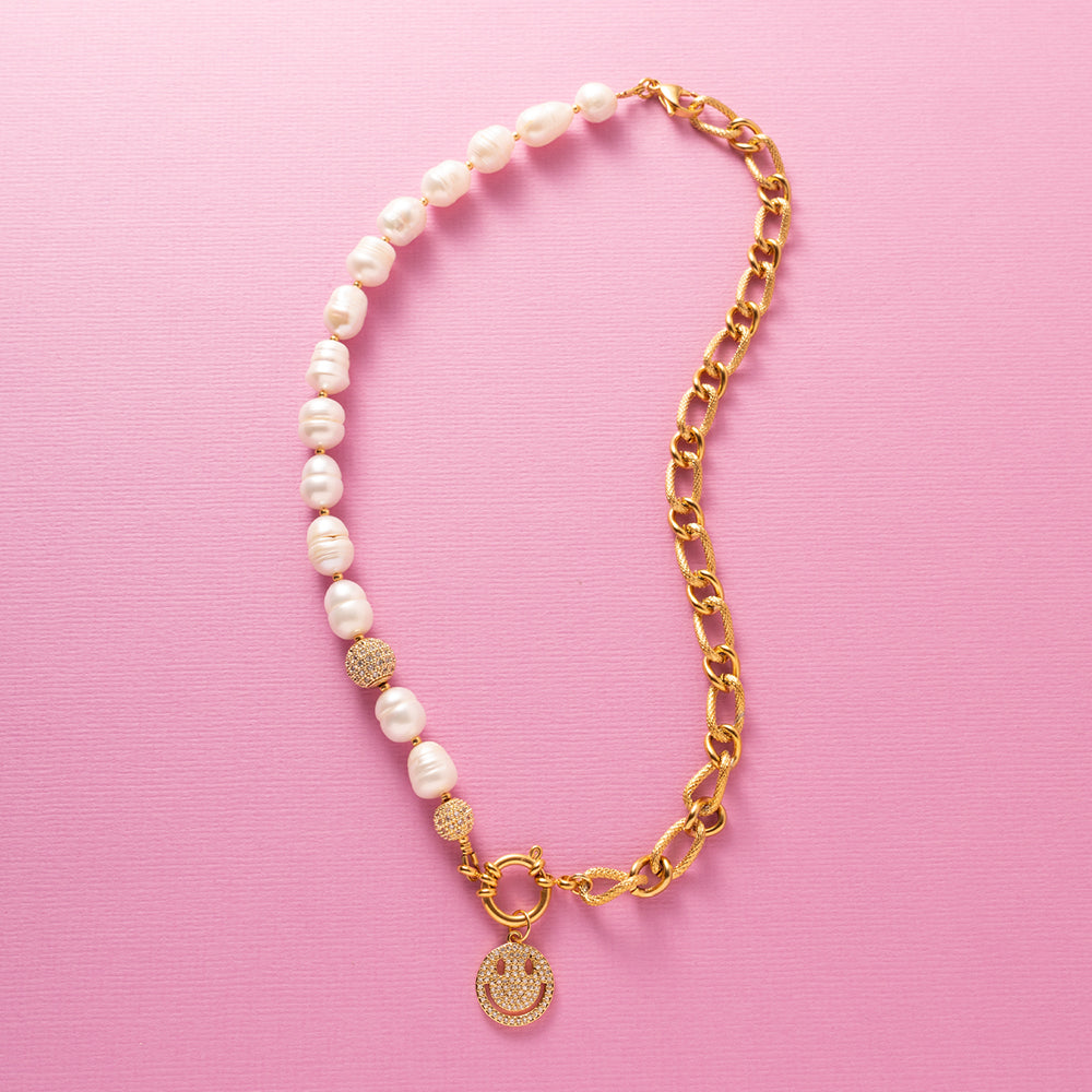 Deze moderne parelketting combineert het beste van twee werelden: de zachte elegantie van zoetwaterparels en de krachtige uitstraling van een opvallende schakel. Aan de voorkant zit een stijlvol boeislot met een zirkonia smiley die je eenvoudig kunt verwijderen. Zo wissel je moeiteloos tussen speels en puur. Een trendy maar tijdloos ontwerp dat zowel stoer als chique gedragen kan worden, passend bij elke stijl en gelegenheid.