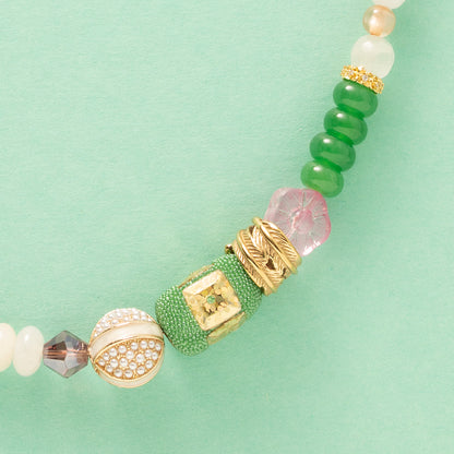 Laat je meevoeren in een dromerige zomerwereld met Wildflower Dreams, een handgemaakte statement ketting in kleurrijke boho-stijl. Deze unieke ketting combineert grote natuursteen kralen, fonkelende zirkonia’s en glaskralen in warme tinten zoals groen, warm oranje, paars, roze en wit. De combinatie van natuurlijke materialen en sprankelende accenten geeft deze ketting een speelse én elegante uitstraling.