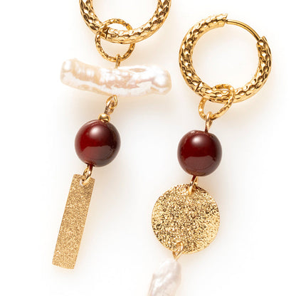 Pearl Rebel combineert stoerheid met elegantie. Het gehamerde goud en de getextureerde plaatjes geven de oorbellen lef en de barokke zoetwaterparels maken ze vrouwelijk. De glanzende two-tone resin kralen in bordeaux/bruin voegen een warm kleuraccent toe.

Het warme bordeaux/bruin geeft diepte en het goud vangt het licht. Zoetwaterparels hebben van nature elk een eigen vorm, dus geen twee paren zijn gelijk. Het asymmetrische ontwerp geeft deze oorbellen uitgesproken karakter. 
