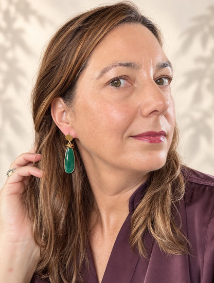 Verde Twist combineert strak goud met een diepe, rijke kleur Groen. Aan een glad gouden oorsteker hangt een knoop van in elkaar gevlochten ringen, gevolgd door een lange, facetgeslepen druppel in diepgroen. De dunne gouden rand geeft de steen een verfijnde afwerking.

Het is een tijdloos ontwerp met karakter: de knoop zorgt voor stoerheid, de druppel voor elegantie.