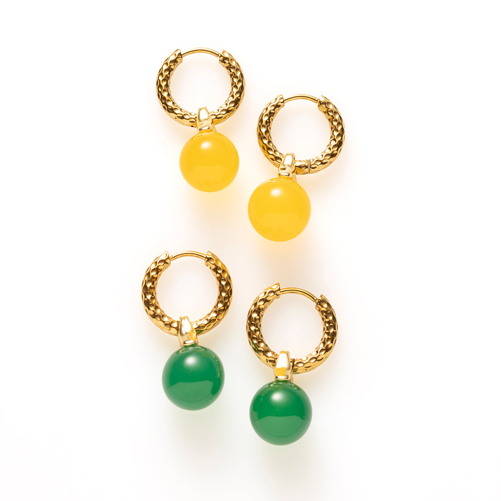Geef je look een warme, zonnige touch met de Golden Hour oorbellen. Aan een goudkleurige klapcreool met fijne gehamerde structuur hangt een glanzend bolletje geel agaat, dat het licht vangt bij iedere beweging. Klein van formaat en rijk van kleur. Subtiel genoeg voor elke dag, opvallend genoeg voor een zomerse jurk of een witte blouse op kantoor.