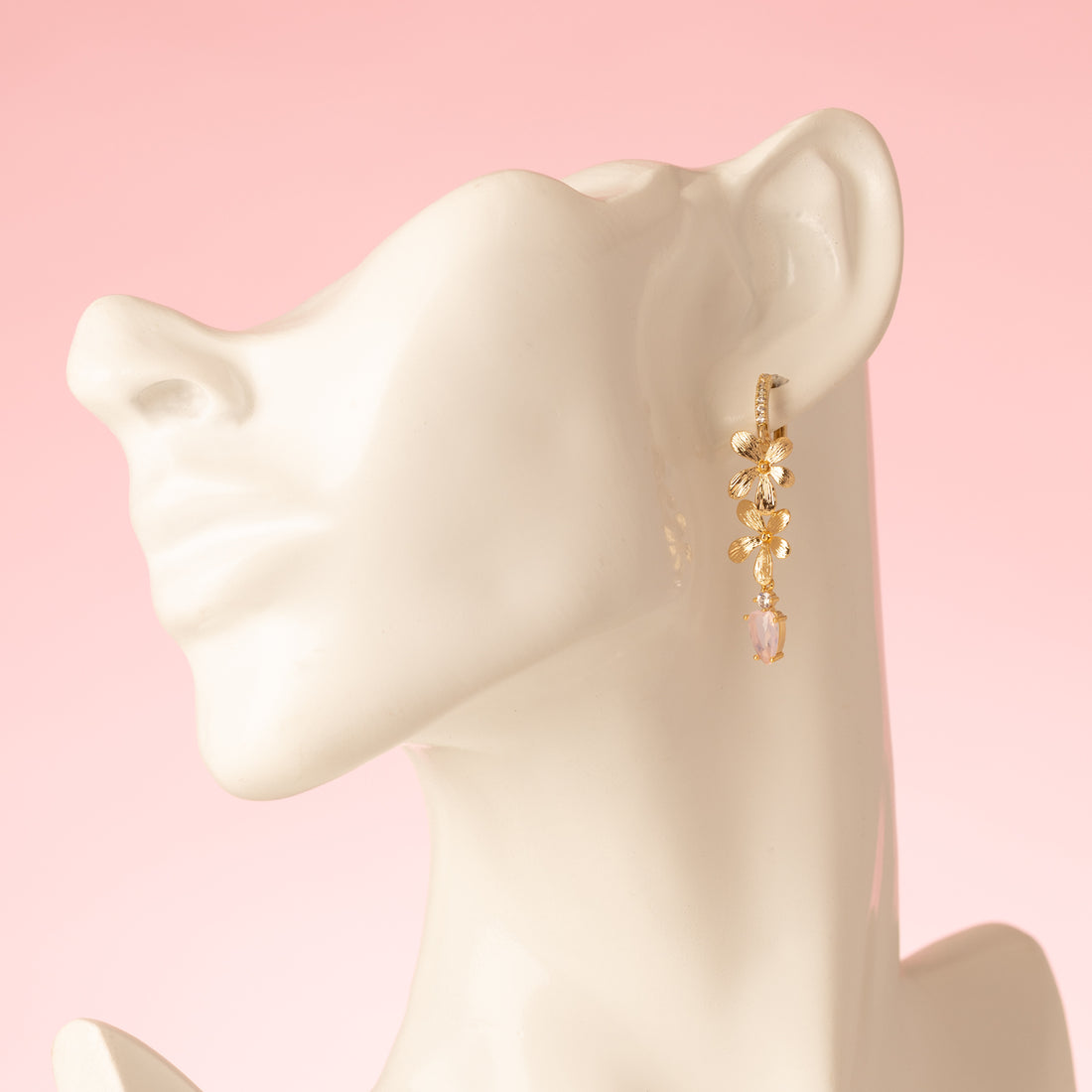 Voeg een subtiel, sprankelend accent toe met de Blushing Bloom oorringen uit de Every Day Glow-collectie. Deze elegante oorringen zijn versierd met twee gouden bloemen en een kleine lichtroze zirkonia druppel die gracieus onderaan hangt. Perfect om je dagelijkse look te verfraaien, naar kantoor of een etentje, en een verfijnd statement te maken dat zowel stijlvol als tijdloos is.