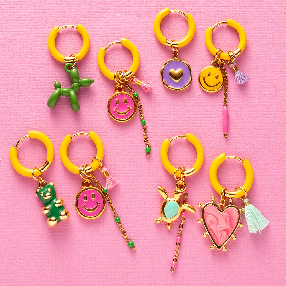 Voeg een sprankje kleur en een vleugje vreugde toe aan je dag met deze kleine gekleurde oorbellen voorzien van eigenzinnige bedels. Deze charmante oorbellen zijn perfect om je outfit op te vrolijken en je een instant geluksgevoel te geven. Bovendien kun je de bedels er zelf afhalen en onderling wisselen. Mix &amp; Match met de andere oorbellen voor dubbel plezier!